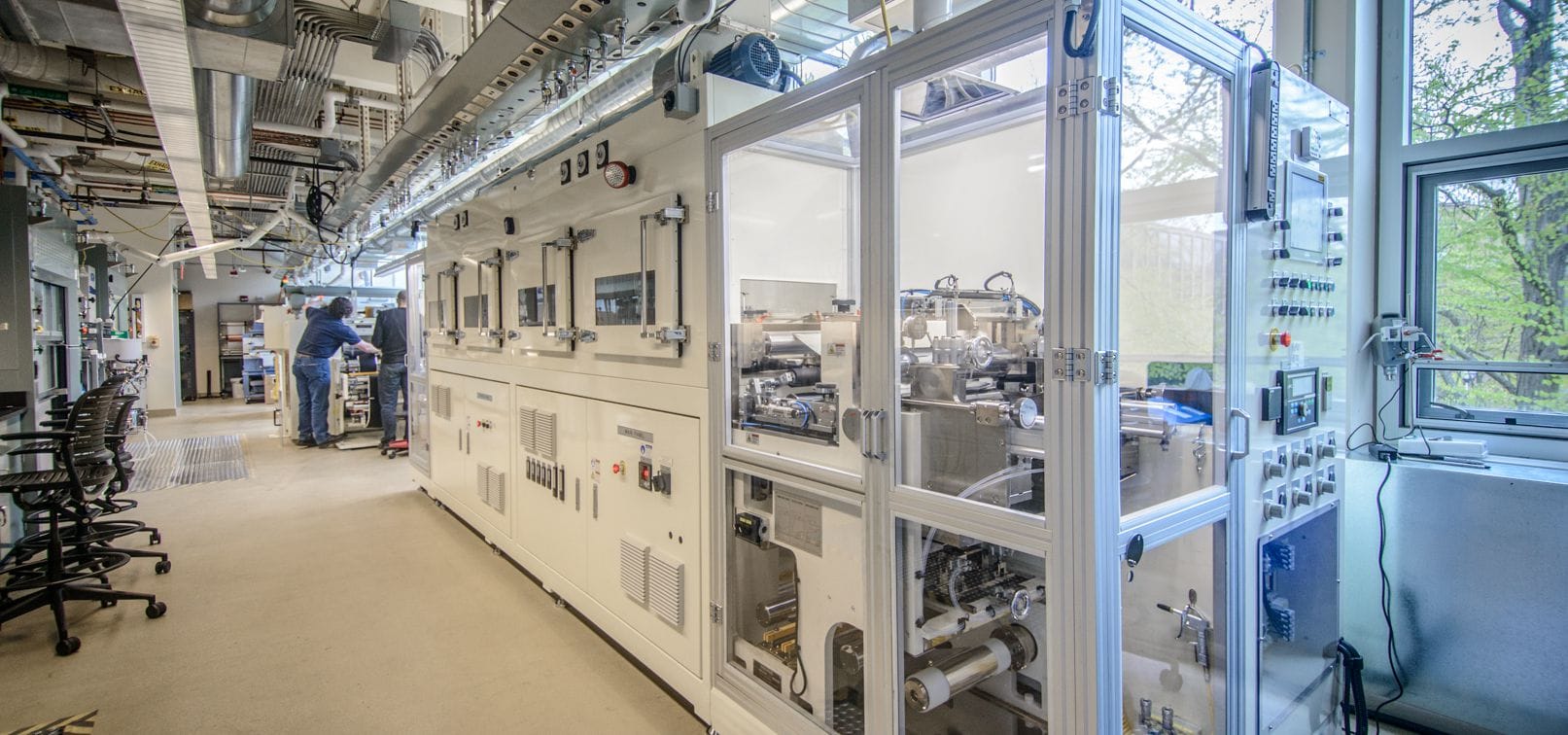 White Interior of battery lab facility with room full of equipment. 