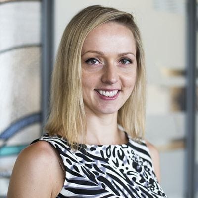 Woman with long blonde hair and zebra pattern top. 