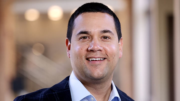 Man with dark hair, with shirt collar and dark sport coat.